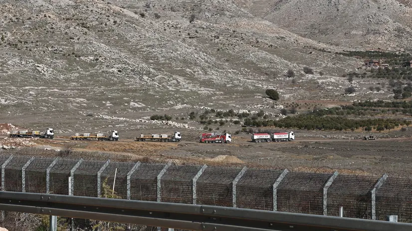 epa11822093 Israeli army securing trucks crossing the buffer zone carrying military logistics, to be used in the new outposts that the Israeli army is establishing on the Syrian side of the border, near the Druze village of Majdal Shams, in the Israeli-annexed Golan Heights, 13 January 2025. Israel's military said that paratroopers' forces, joined by other troops, are conducting 'defense activities' to prevent 'any threat' and are deployed in key positions within the buffer zone. EPA/ATEF SAFADI
