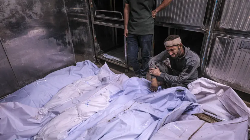 epa12238934 A man mourns over dead bodies at the Al-Shifa hospital in Gaza City, 15 July 2025. According to the Palestinian Ministry of Health in Gaza, 12 members of the Azzam were killed following an Israeli airstrike the previous nighth in Tal Al Hawa neighbourhood. EPA/MOHAMMED SABER