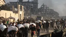 epa12191492 Displaced Palestinians carry relief packages along Rashid Street, west of Jabalia, 22 June 2025, after humanitarian aid trucks entered the northern Gaza Strip through the Israeli-controlled Zikim crossing, northwest of Gaza City. More than 55,700 Palestinians have been killed in the Gaza Strip, according to the Palestinian Ministry of Health, since Israel launched a military campaign in the strip in response to a cross-border attack led by the Palestinian militant group Hamas on 07 October 2023. EPA/HAITHAM IMAD