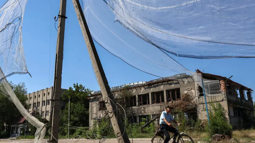 epa12239950 A handout photo made available by the press service of the 65th Separate Mechanised Brigade of Ukrainian Armed Forces shows a local man riding a bike on a street protected by the anti-drone nets of various types amid the ongoing Russian invasion in the city of Orikhiv, Zaporizhzhia region, Ukraine, 15 July 2025. Russian troops entered Ukrainian territory on 24 February 2022, starting a conflict that has provoked destruction and a humanitarian crisis. EPA/Press service of the 65th Mechanized Brigade / HANDOUT HANDOUT EDITORIAL USE ONLY/NO SALES