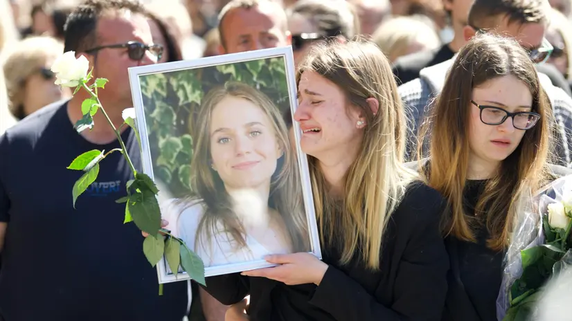 Dietro alla bara una ragazza alza tra la folla una foto il cui la giovane vittima appare sorridente durante il corteo funebre che accompagna il feretro di Ilaria Sula verso il cimitero cittadino, che dista circa un chilometro, dove è prevista una breve cerimonia laica per l'ultimo saluto alla giovane uccisa a Roma, Terni, 07 aprile 2025. ANSA/ FRANCESCO PATACCHIOLA