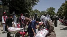 epa12209051 Afghan refugees returning from Iran receive food rations during a ceremony in Kabul, Afghanistan, 01 July 2025. The Afghan Red Crescent, distributed food and non-food items to 200 needy families, including returnees from Iran, in an event attended by officials from the organization and the Silab Charity Foundation. The Afghan Red Cross has urged for increased global aid for returnees, citing the return of over 800,000 Afghans from Iran in the past six months and highlighting the dire conditions faced by these individuals. EPA/SAMIULLAH POPAL
