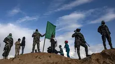 epa11909395 Izz ad-Din al-Qassam fighters look on following the handover of the bodies of four Israeli hostages to the Red Cross, in Khan Yunis, southern Gaza Strip, Thursday, 20 February, 2025. Hamas was set to hand over the bodies of four Israeli captives, including that of youngest hostage Kfir Bibas, as part of the ongoing Gaza ceasefire deal. Hamas said in November 2023 that the two Bibas boys and their mother had been killed in an Israeli airstrike on Gaza. EPA/HAITHAM IMAD
