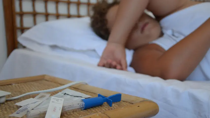 Un bambino di 10 anni disteso a letto dopo aver misurato la temperatura e aver fatto un test covid con esito positivo a San Vito Lo Capo, 21 agosto 2023. ANSA / CARMELA GIUDICE (incidenza, casi, covid, febbre, bambino, influenza, generica, simbolica, malattia, bambini)