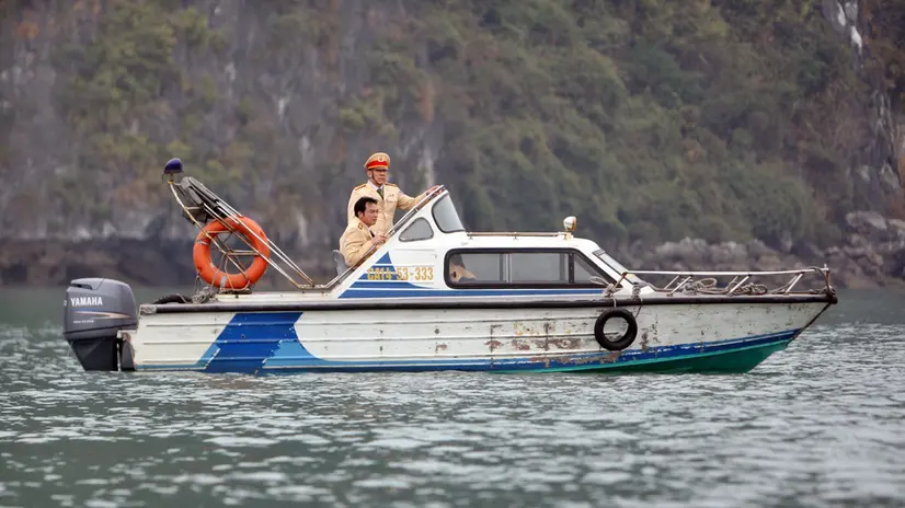 epa02589095 Police watch the tourist boat 'Dream Voyage' being salvaged near to Titop island, in Ha Long Bay, northern Vietnam, 18 February 2011. Vietnamese police detained for questioning the captain and four crew members involved in a boat tragedy that left 12 tourists dead the previous day. The accident occurred on 17 February at Ha Long Bay when a tourist boat carrying 27 people sank. Nguyen Khuong Duy, a Vietnamese Australian, one of 15 survivors in the tragedy told local media the accident happened when people were still sleeping in the boat. Those on the top deck had time to escape before the boat sank. Twelve people died in the sinking of a tourist boat and 15 have been rescued, officials said. EPA/LUONG THAI LINH