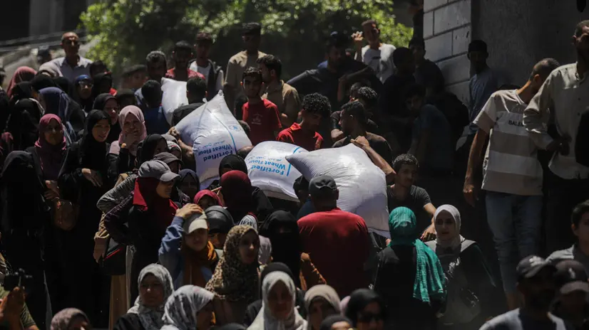 epa12198715 Displaced Palestinians wait to receive aid through the WFP after it successfully arrived at the organization’s warehouses in Gaza City, 26 June 2025. According to the UN half a million people, or one in five people in the Strip are facing starvation while the entire population of the Gaza Strip continues to face a critical risk of famine following 19 months of conflict, mass displacement and severe restrictions on humanitarian aid. EPA/MOHAMMED SABER