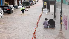 epa12242239 People wade through an inundated street in Gwangju, South Korea, 17 July 2025, following torrential rains that hit the city. EPA/YONHAP SOUTH KOREA OUT