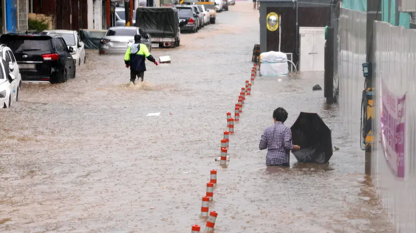 epa12242239 People wade through an inundated street in Gwangju, South Korea, 17 July 2025, following torrential rains that hit the city. EPA/YONHAP SOUTH KOREA OUT