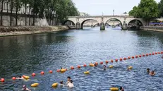 epa12217301 People swim near the Pont Marie, one of the three safe swimming areas that opened to the public on the Seine River, in Paris, France, 05 July 2025. From 05 July to 31 August 2025, people will be able to swim in three safe swimming areas on the Seine river, an activity that has been banned since 1923. EPA/TERESA SUAREZ