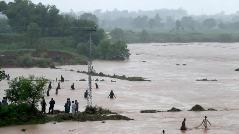 epa12243312 Local people catch fish in the floodwaters during heavy monsoon rains at the Ladian village in Rawalpindi, Pakistan, 17 July 2025. Heavy monsoon rains continue to pound Pakistan, posing risks of flash floods, landslides, and urban flooding across several provinces. EPA/SOHAIL SHAHZAD