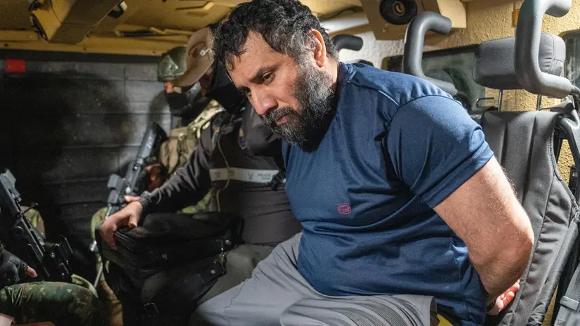 epa12198026 Drug trafficker Jose Adolfo Macias Villamar 'Fito' (R) is guarded as he is moved in Guayaquil, Ecuador, 25 June 2025. 'Fito' arrived at the Guayaquil Air Base after being captured in the city of Manta, and will be held in the maximum security prison La Roca. EPA/MAURICIO TORRES