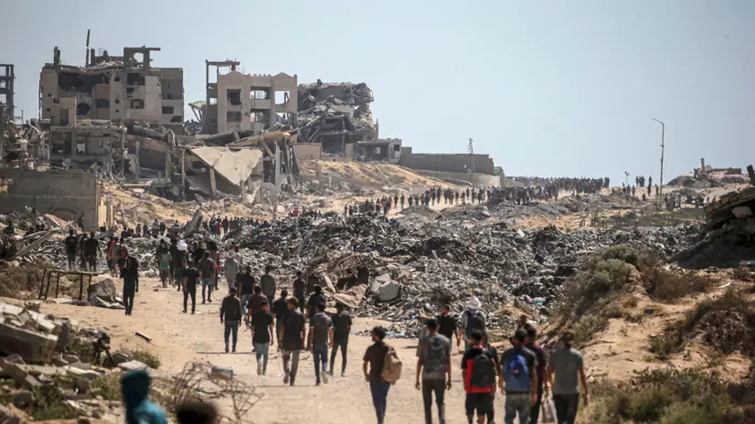 epa12249941 Internally displaced Palestinians walk along Rashid Road in western Jabalia, northern Gaza Strip, 20 July 2025. According to the Palestinian Ministry of Health in Gaza, at least 67 people were killed while trying to receive humanitarian aid in the Zikim area, northern Gaza. EPA/MOHAMMED SABER