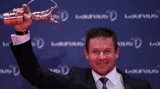 epa03619675 Austrian skydiver Felix Baumgartner poses with Laureus award to best actions sportive man during ceremony at the Municipal Theater in Rio de Janeiro, Brazil, 11 March 2013. Baumgartner has the world record in high jump for his jump from the stratosphere. EPA/Antonio Lacerda