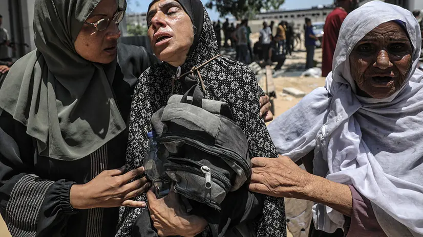 epa12250219 A Palestinian mother (C) hugs the bag of her son while mourning after he was shot dead at a food distribution point, at Al-Shifa Hospital in Gaza City, 20 July 2025. According to the Palestinian Ministry of Health in Gaza, at least 67 people were killed while trying to receive humanitarian aid in the Zikim area. EPA/MOHAMMED SABER
