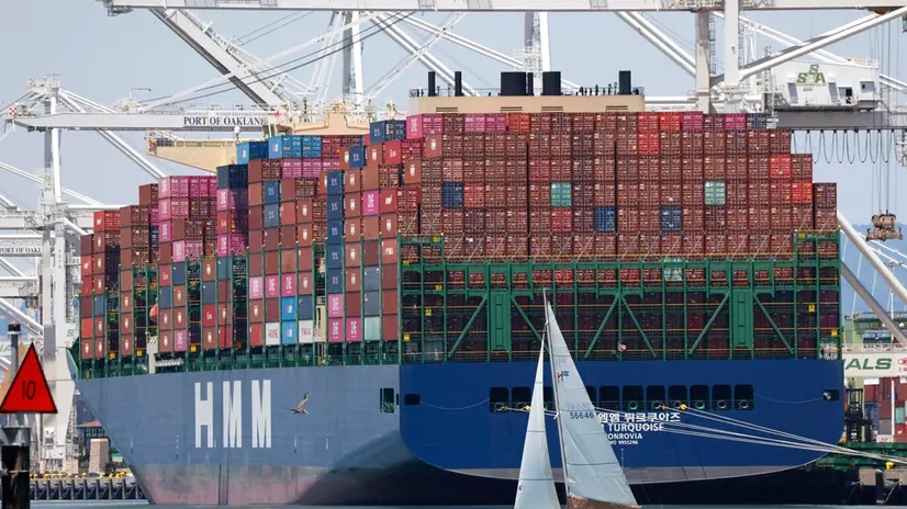 epa12238224 A sailboat sails past a container ship at the Port of Oakland in Oakland, California, USA, 14 July 2025. Recent tariff increases and trade policies, particularly those related to China, have significantly affected the port’s operations and container volume. Shipping lines have been canceling voyages and skipping ports (known as 'blank sailings') in response to the uncertainty and reduced demand caused by tariffs, leading to a decline in container traffic at the Port of Oakland. Last week, US President Trump sent a letter to European Union leaders stating that he would impose a 30 percent tariff on goods imported from the EU beginning 01 August. Trump also threatened to impose 25 percent tariffs on Japan and South Korea, 30 percent on Mexico, and 35 percent on Canada. EPA/JOHN G. MABANGLO