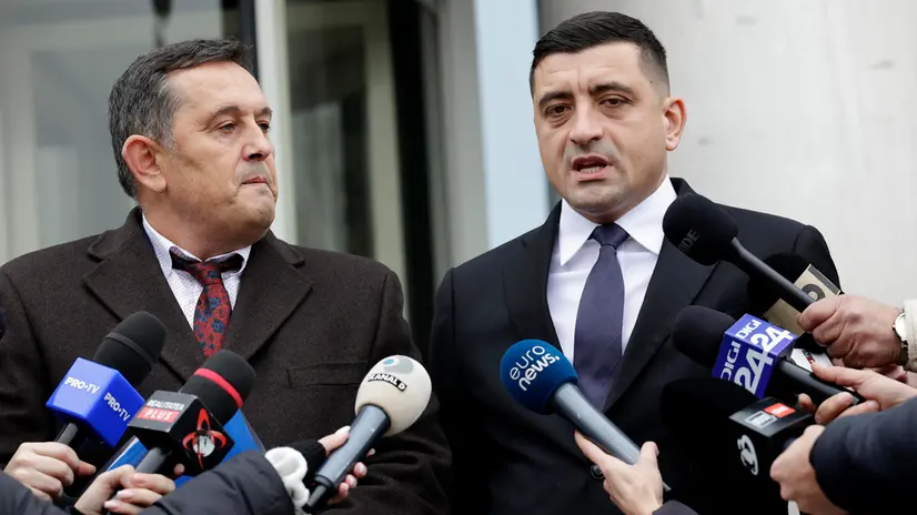 epa11770363 The leader of the ultra-nationalist party AUR (Alliance for the Union of Romanians), George Simion (R), accompanied by the lawyer and AUR member of the European Parliament, Gheorghe Piperea (L), makes a statement outside the High Court of Cassation and Justice headquarters (background) in Bucharest, Romania, 11 December 2024. The AUR filed an appeal to the decision by Romania's Constitutional Court to annul the first round of the presidential elections. EPA/ROBERT GHEMENT
