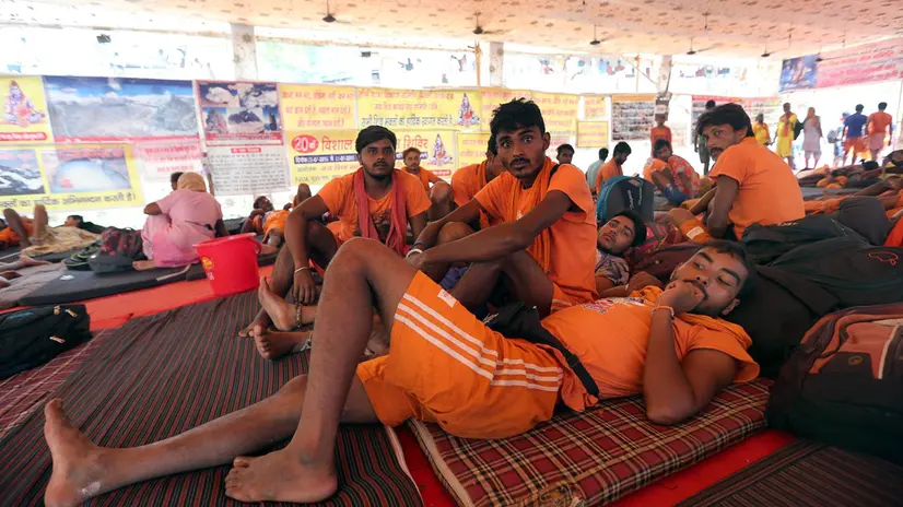 epa05447246 Kanwariyas (devotee of Shiva, the Hindu mythological God of destruction) rest at a shelter during Kanwar Yatra (annual pilgrimage of devotees of Shiva) in New Delhi, India, 29 July 2016. In the month of Shraavana (July-August), Kanwariyas collect holy water from the Ganges river and carry it in colorfully decorated containers to their hometown in order to perform the Abhisheka anointing ritual at their local Shiva temples. EPA/HARISH TYAGI