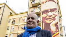 Marco Morricone davanti al murale che ricorda il padre - © www.giornaledibrescia.it