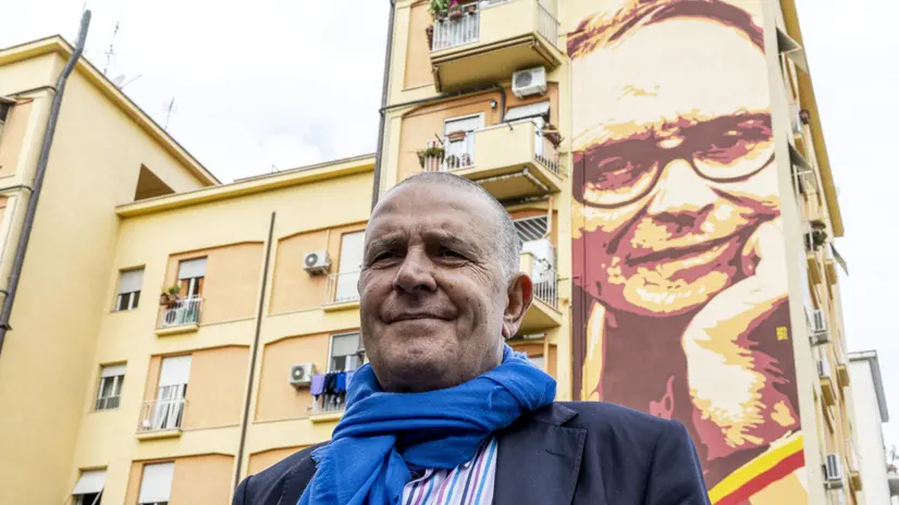 Marco Morricone davanti al murale che ricorda il padre - © www.giornaledibrescia.it