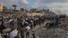 epa12191493 Displaced Palestinians carry relief packages along Rashid Street, west of Jabalia, 22 June 2025, after humanitarian aid trucks entered the northern Gaza Strip through the Israeli-controlled Zikim crossing, northwest of Gaza City. More than 55,700 Palestinians have been killed in the Gaza Strip, according to the Palestinian Ministry of Health, since Israel launched a military campaign in the strip in response to a cross-border attack led by the Palestinian militant group Hamas on 07 October 2023. EPA/HAITHAM IMAD