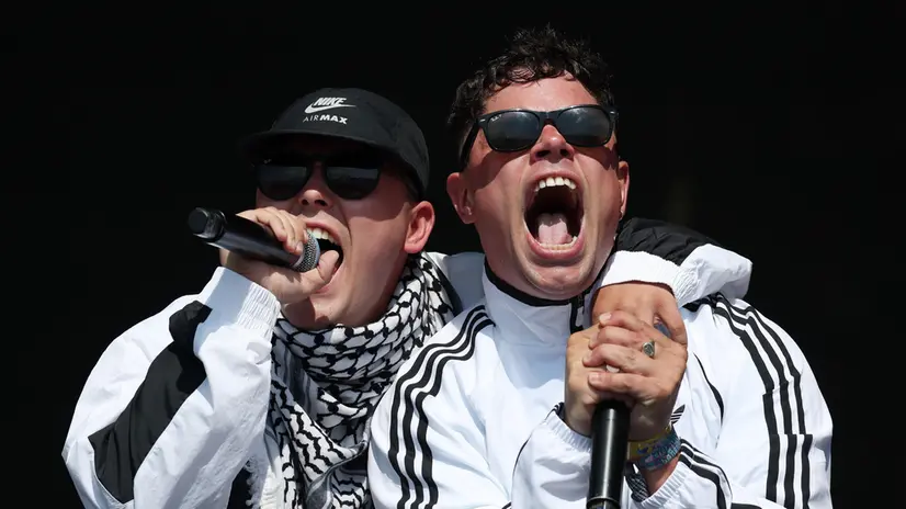 epa12203330 Kneecap's Mo Chara (L) and Moglai Bap (R) perform on the West Holts stage during day four of the Glastonbury Festival at Worthy Farm near Pilton, Somerset, Britain, 28 June 2025. The Glastonbury Festival of Contemporary Performing Arts 2025 runs from 25 to 29 June 2025. EPA/ANDY RAIN