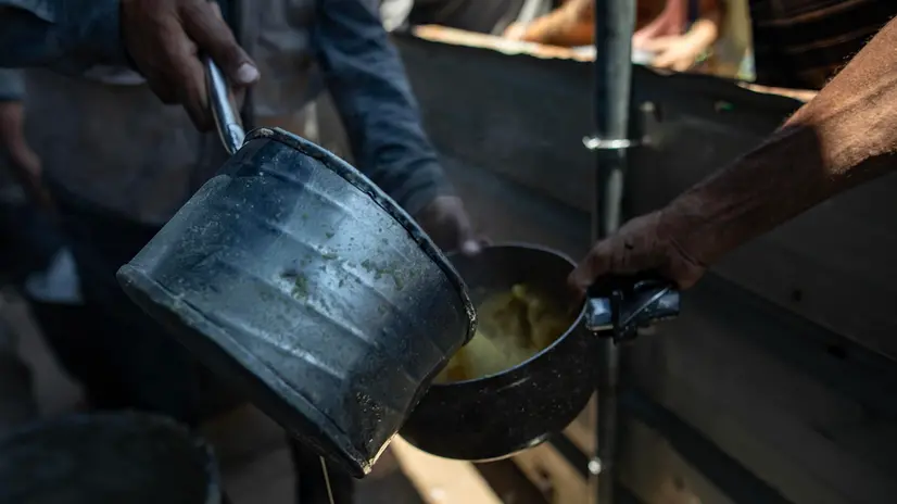 epa12247564 Internally displaced Palestinians gather outside a charity kitchen to receive limited food rations amid the lack of food availability, in Gaza City, 19 July 2025. EPA/HAITHAM IMAD