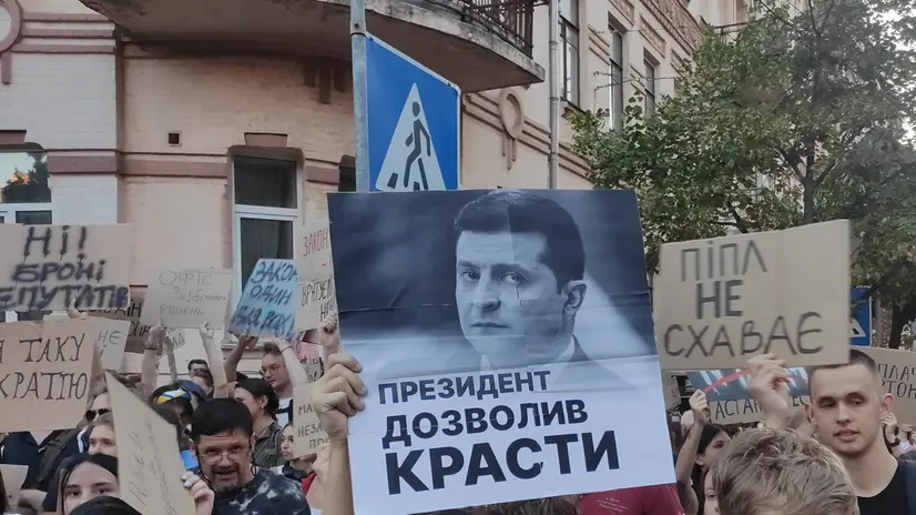 epa12257262 Protesters hold signs during a demonstration in Kiev, Ukraine, 23 July 2025. Thousands of Ukrainians gathered on the second day of protests against the passage of a law that critics believe strips two key anti-corruption agencies of their independence by placing them under state control. EPA/Rostyslav Averchuk