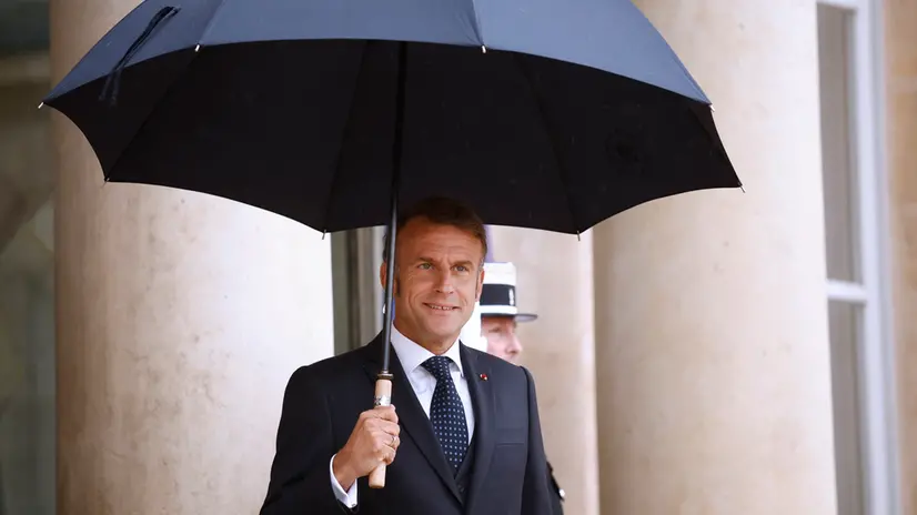 epa12258537 French President Emmanuel Macron holds an umbrella as he awaits the Lebanese Prime Minister Nawaf Salam (not pictured) upon his arrival at the Elysee Palace in Paris, France, 24 July 2025. This marks the first official visit of the Lebanese prime minister to France, with the purpose to reaffirm the diplomatic relationship between the two countries. EPA/YOAN VALAT