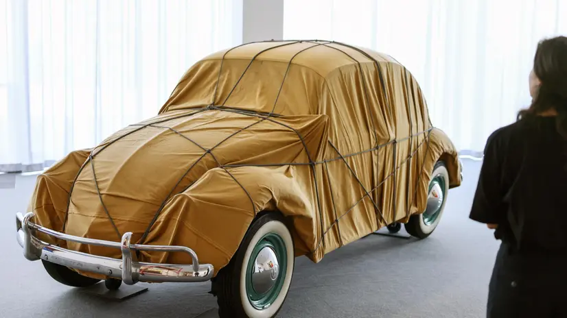epaselect epa12169682 A woman stands before the "Wrapped 1961 Volkswagen Beetle Saloon" by artists Christo and Jeanne-Claude, at the Neue Nationalgalerie in Berlin, Germany, 11 June 2025. The artwork is showcased to mark the 30th anniversary of the artistsâ€™ "Wrapped Reichstag". EPA/HANNIBAL HANSCHKE