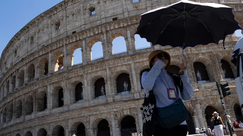 Turisti al centro della capitale, si proteggono dal sole con gli ombrelli, nelle ore più calde. Roma, 1 luglio marzo 2025 ANSA/MASSIMO PERCOSSI
