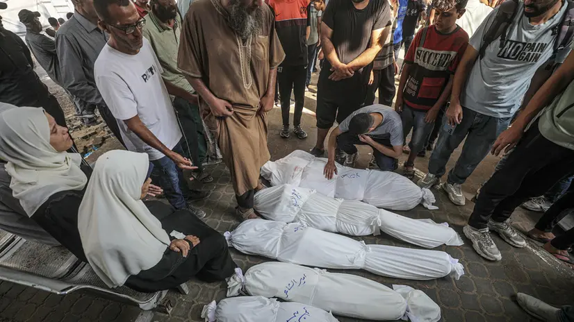 epa12255278 Relatives mourn over the shrouded bodies of Al Shaer family members at the Al-Shifa in Gaza City, 23 July 2025. According to the Palestinian Ministry of Health in Gaza, more than 36 Palestinians were killed, eight of them from the Al Shaer family, following Israeli airstrikes last night and early today. EPA/MOHAMMED SABER