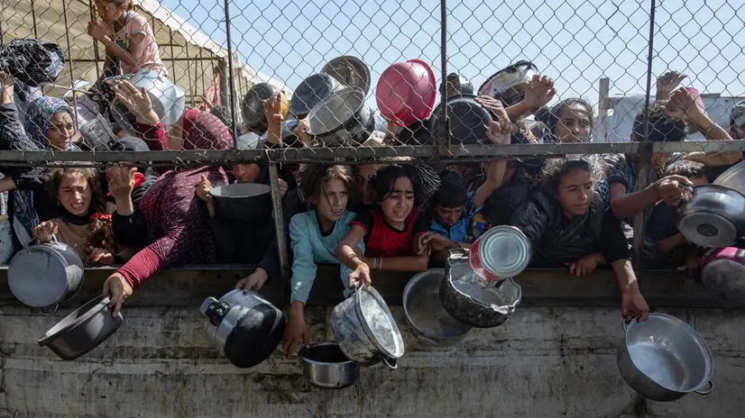 epa12144612 Internally displaced Palestinians gather outside a charity kitchen to receive limited rations amid a shortage of food, in Khan Younis, southern Gaza Strip, 30 May 2025. The United Nations has warned that "the entire population of Gaza is facing the risk of famine" since Israel closed border crossings on 02 March 2025, preventing the entry of essential supplies. The Gaza Government Media Office reported on 24 May that at least 58 people died due to malnutrition, and nearly 250 others due to a lack of food and medicine. EPA/HAITHAM IMAD