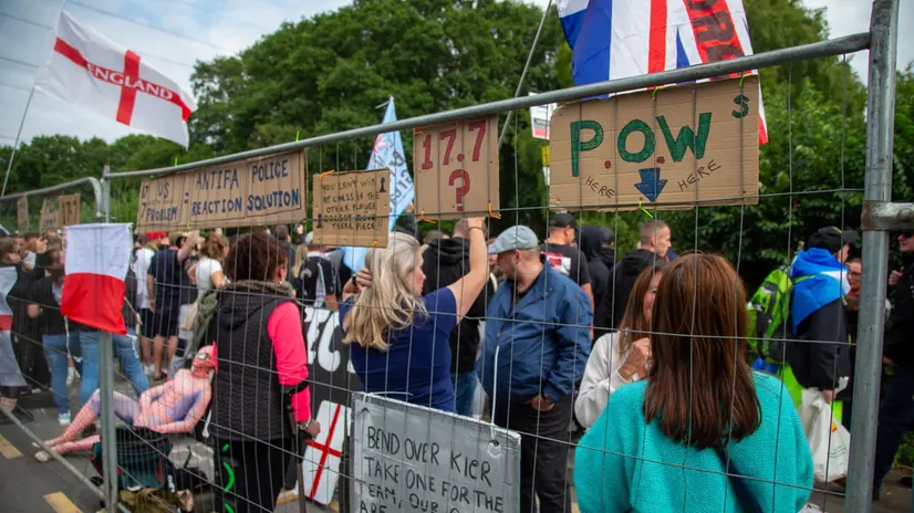 epa12266256 Far right protesters stand behind a police fence outside a hotel housing migrants in Epping, Britain, 27 July 2025. Stand Up To Racism (SUTR) group called for a protest to 'oppose spreading racism and hate by far right' following recent unrest outside the Bell Hotel housing asylum seekers in Epping. EPA/TAYFUN SALCI