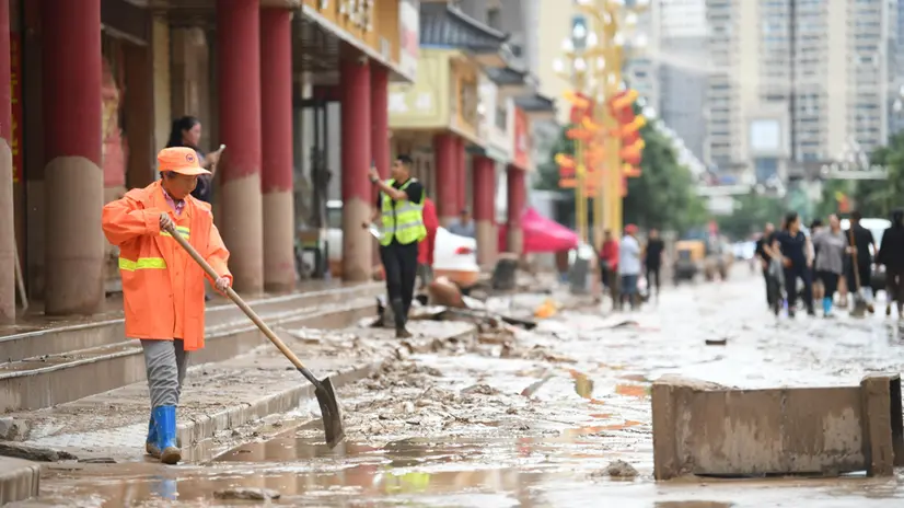 epa12264096 A sanitation worker clears up a street following a flood in the Wuqi County of Yan'an City, Shaanxi Province, China, 26 July 2025. Heavy rainfall has affected Wuqi County since 24 July, resulting in severe flooding. EPA/XINHUA / Zhang Bowen CHINA OUT / UK AND IRELAND OUT / MANDATORY CREDIT EDITORIAL USE ONLY EDITORIAL USE ONLY
