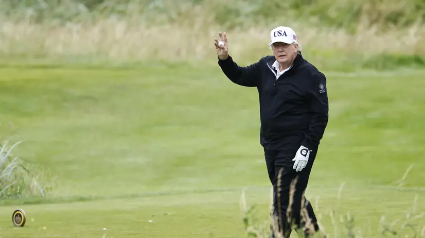 epa12265363 US President Donald J. Trump holds up a golf ball as he plays golf at Trump Turnberry golf course during a private visit in Turnberry, Scotland, Britain, 27 July 2025. US President Trump is in Scotland where he will visit his golf courses and meet with UK Prime Minister Keir Starmer. EPA/TOLGA AKMEN