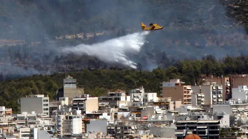 epa12268731 A firefighting airplane tries to extinguish a wildfire on Ymittos mountain, east of Athens, Greece, 28 July 2025. The wildfire burning scrub and low vegetation is in remission, according to an update by the Fire Department. EPA/ORESTIS PANAGIOTOU