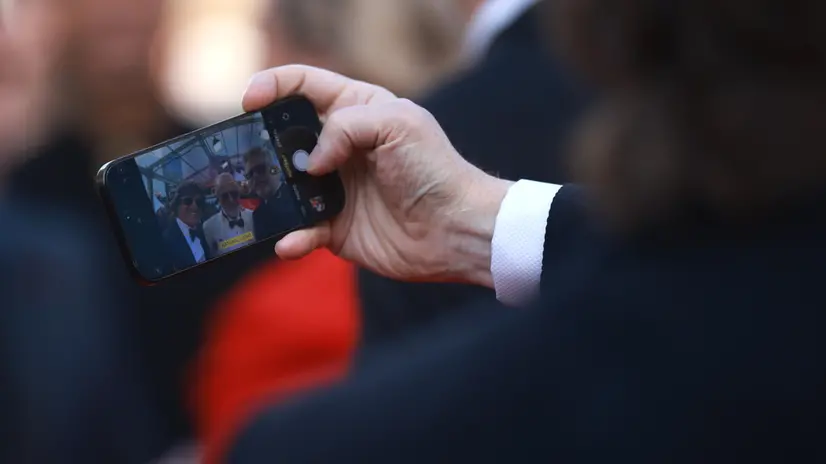 epa12100070 Tom Cruise (L) appears on a mobile phone screen at the premiere for 'Mission: Impossible - The Final Reckoning' during the 78th annual Cannes Film Festival, in Cannes, France, 14 May 2025. The film festival runs from 13 to 24 May 2025. EPA/CLEMENS BILAN