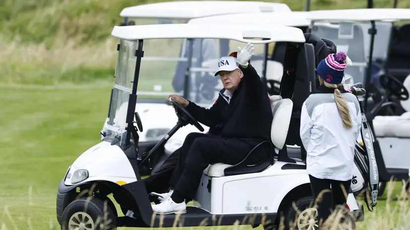epa12265352 US President Donald J. Trump (L) waves from his golf buggy while playing golf at Trump Turnberry golf course during a private visit in Turnberry, Scotland, Britain, 27 July 2025. US President Trump is in Scotland where he will visit his golf courses and meet with UK Prime Minister Keir Starmer. EPA/TOLGA AKMEN