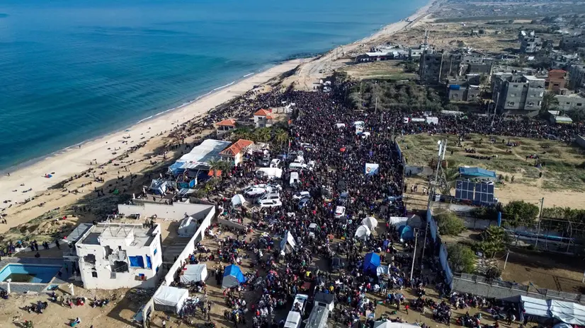 epa11854261 A photograph taken by drone shows Palestinian families waiting to return to the northern Gaza Strip from the southern Gaza Strip, along Rashid Road, west of the Nuseirat refugee camp, central Gaza Strip,26 January 2025. EPA/HAITHAM IMAD