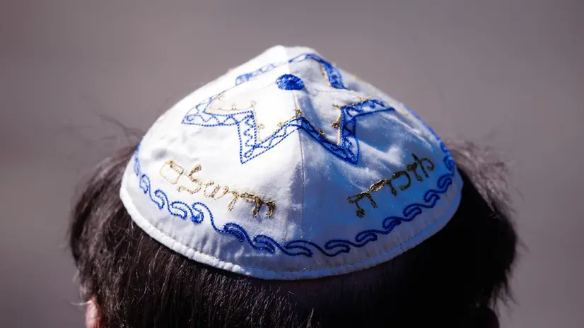 epa12058838 A participant wears a kippah during a memorial event at the former concentration camp Bergen-Belsen to mark the 80th anniversary of the concentration camp's liberation, in Lohheide, Germany, 27 April 2025. Bergen-Belsen, initially established as a prisoner-of-war camp, became a concentration camp in 1943, where more than 52,000 prisoners died, until it was liberated by the British forces on 15 April 1945. EPA/CLEMENS BILAN