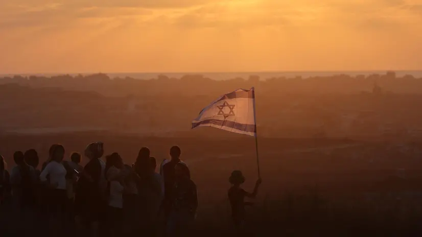 epa12273302 Israeli right-wing settlers waving a national flag march during a rally calling for the return of Jewish settlements in Gaza, at an area near the border overlooking the Gaza Strip, in southern Israel, 30 July 2025. EPA/ABIR SULTAN
