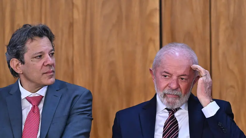 epa12269438 Brazilian President Luiz Inacio Lula da Silva (R) along with Finance Minister Fernando Haddad (L) participate in the signing ceremony of the complementary bill regulating the "Acredita Exportar" program at the Planalto Palace in Brasilia, Brazil, 28 July 2025. Lula asked his US counterpart, Donald Trump, to reflect on Brazil's importance and to sit down to negotiate the additional 50% tariff on Brazilian products arriving in the US, announced by the Republican leader for August 1. EPA/Andre Borges