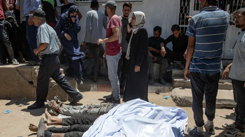 epa12249285 Palestinians mourn over the bodies of people who were shot dead at a food distribution point, at Al-Shifa Hospital in Gaza City, 20 July 2025. According to the Palestinian Ministry of Health in Gaza, at least 67 people were killed while trying to receive humanitarian aid in the Zikim area. EPA/HAITHAM IMAD