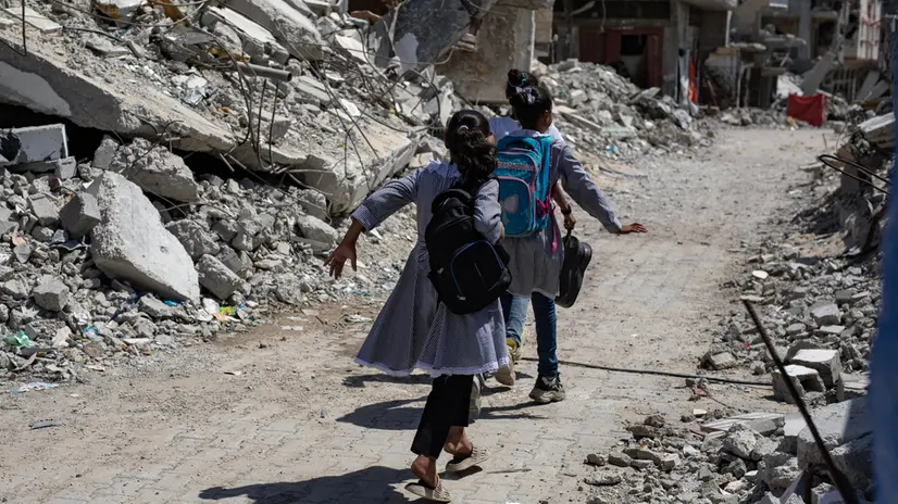 epa11599974 Palestinian children walk past destroyed buildings as they head to class in the Khan Younis camp, southern Gaza Strip, 12 September 2024. Palestinian teacher Israa Abu Mustafa (not pictured) set up a makeshift classroom in a tent built on the rubble of her old house. According to a statement released by the Palestinian Ministry of Education, more than 650,000 students in the Gaza Strip are being deprived of their right to education for the second academic year in a row. At least 84 percent of schools in the Gaza Strip â€˜require full reconstruction or significant rehabilitation before schooling can resumeâ€™, the United Nations Children's Fund (UNICEF) reported in September 2024. More than 41,000 Palestinians and over 1,400 Israelis have been killed, according to the Palestinian Health Ministry and the Israel Defense Forces (IDF), since Hamas militants launched an attack against Israel from the Gaza Strip on 07 October 2023, and the Israeli operations in Gaza and the West Bank which followed it. EPA/HAITHAM IMAD