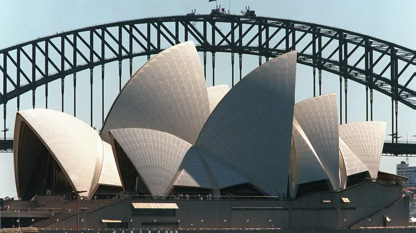 SYD04-19980407-SYDNEY, AUSTRALIA:The majestic white tiled sails of the Opera House are framed by the arch of the Sydney Harbour Bridge 07 April. Renowned Danish architect Jorn Utzon, designer of the Opera House, is to be honoured with the keys to the City of Sydney some 32 years after he left following a bitter row over the masterpiece he was never allowed to complete. EPA PHOTO/AFP/WILLIAM WEST/PW