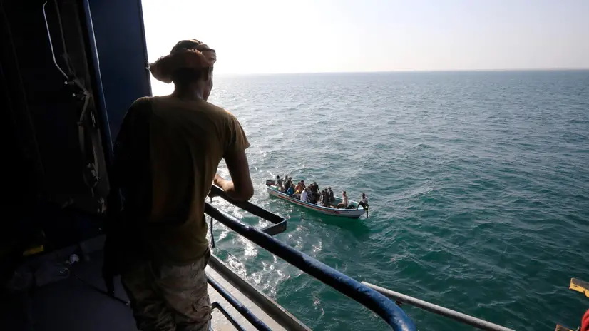 epa11014311 A boat carries people as a Houthi fighter keeps watch on the deck of the Galaxy Leader cargo ship, seized by the Houthis offshore of the Al-Salif port on the Red Sea in the province of Hodeidah, Yemen, 05 December 2023 (issued 06 December 2023). Yemen's Houthis on 06 December 2023 claimed responsibility for the launch of the barrage of ballistic missiles toward Israel in support of the Palestinian people in the Gaza Strip, according to a statement by Houthis spokesman Yahya Saree. The Houthis vowed to continue their efforts to prevent Israeli ships from navigating in the Arabian and Red Seas, in retaliation for Israel's airstrikes on the Gaza Strip. Thousands of Israelis and Palestinians have died since the militant group Hamas launched an unprecedented attack on Israel from the Gaza Strip on 07 October, and the Israeli strikes on the Palestinian enclave which followed it. EPA/YAHYA ARHAB