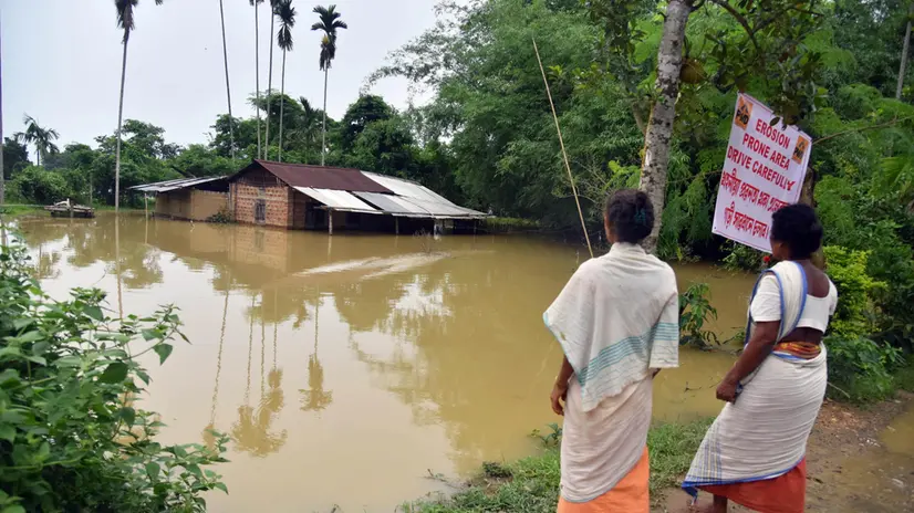 epa12149117 People look at a flooded house in Nagaon district of Assam, India, 01 June 2025. At least 25 people have been killed across north-east India following days of relentless monsoon rains that triggered widespread landslides and flash floods, officials have confirmed. In Assam, heavy rain continues to batter several parts of the state. According to the Assam State Disaster Management Authority (ASDMA), the districts worst affected include Dhemaji, South Salmara, Lakhimpur, Dibrugarh, Golaghat, Darrang, Nagaon, Karbi Anglong, Kamrup, Biswanath, Tinsukia and West Karbi Anglong. EPA/ANUWAR ALI HAZARIKA