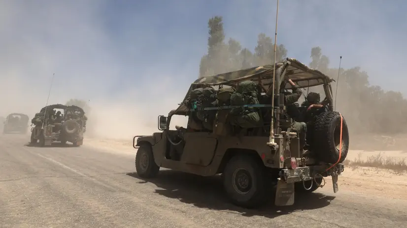 epa12118914 Israeli soldiers on military vehicles move towards the southern Gaza Strip border near Khan Yunis, seen from southern Israel, 20 May 2025. Israel's military continued to strike targets across the Gaza Strip as part of its 'Gideon's Chariots' operation. EPA/ATEF SAFADI
