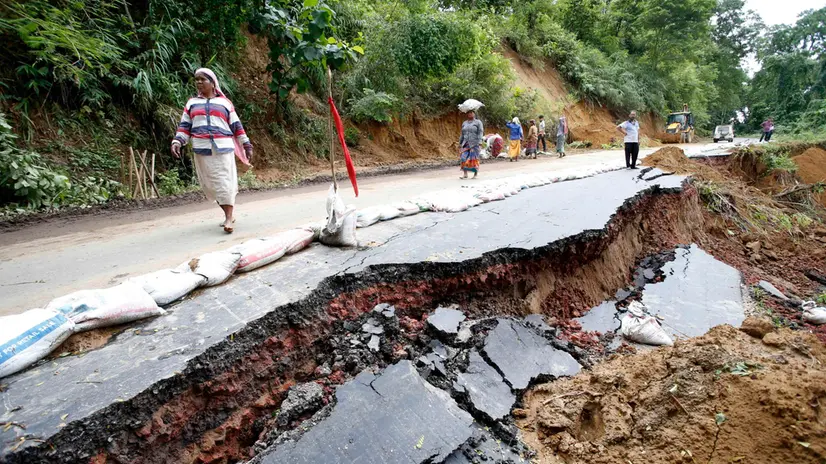 epaselect epa11565091 People walk past a damaged road following floods in Amarpur Agartala, Tripura state, northeastern India, 25 August 2024 (issued 26 August 2024). Tripura Chief Minister Manik Saha said the unprecedented floods in the state have caused an estimated loss of Rs 15,000 crore or $1.8 billion USD and that at least 24 people have died in flood related accidents, with 128,000 people having taken shelters in 557 relief camps, a state official also added. EPA/JAYANTA DEY