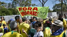 epa12249903 A man holds a sign reading 'Out with Moraes', referring to Brazilian Supreme Court Justice Alexandre de Moraes, during a protest in support of former Brazilian President Jair Bolsonaro in front of the Central Bank in Brasilia, Brazil, 20 July 2025. EPA/ANDRE BORGES